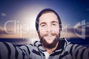 Composite image of portrait of happy hipster with hooded shirt