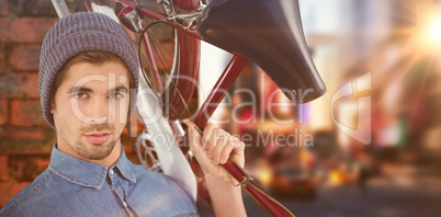 Composite image of portrait of hipster carrying bicycle