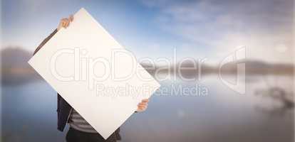 Composite image of man holding billboard in front of face