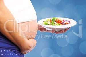 Composite image of pregnant woman eating a salad