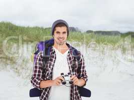 Composite image of happy hipster wearing backpack holding binocu