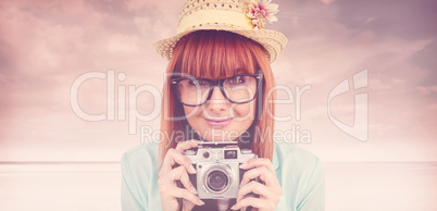 Composite image of portrait of a smiling hipster woman holding r