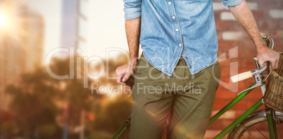 Composite image of portrait of hipster standing with bicycle