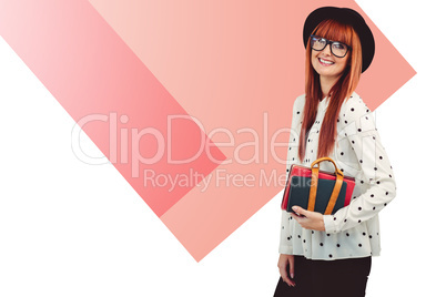 Composite image of smiling hipster woman holding book belt