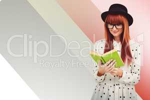 Composite image of hipster woman reading a green book