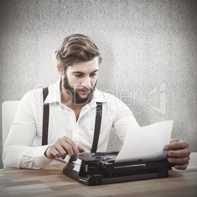 Composite image of hipster using typewriter at desk in office Composite image of hipster using typewriter at desk in office