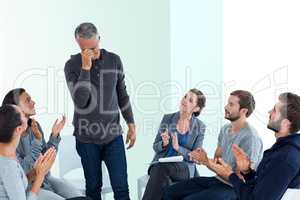 Composite image of rehab group applauding delighted man standing