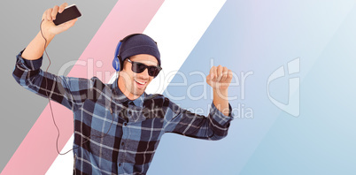 Composite image of happy hipster wearing headphones enjoying mus