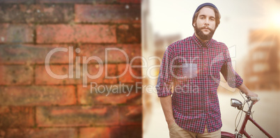 Composite image of portrait of confident hipster with bicycle