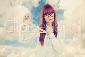 Composite image of smiling hipster woman holding a clothes hange