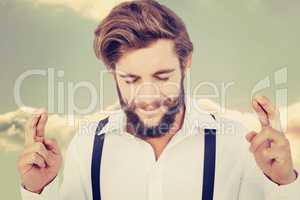 Composite image of hipster with fingers crossed