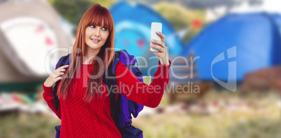 Composite image of smiling hipster woman with a travel bag takin