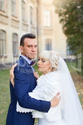 Bride and groom embrace on a walk in the countryside for a walk