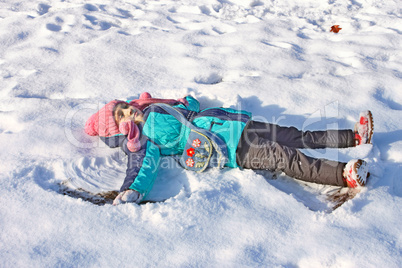 Little girl lying on a snow