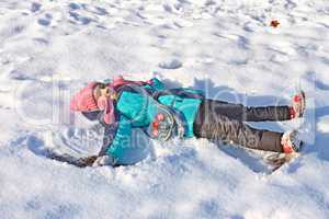 Little girl lying on a snow