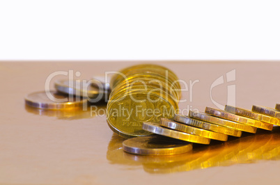 Stack of coins close-up on a gold background