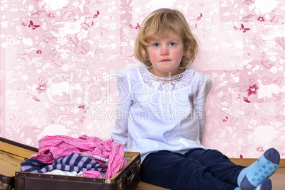 Little girl with clothes suitcase