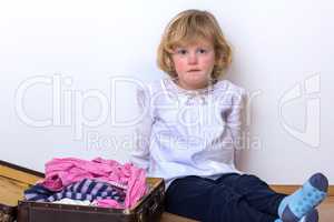 Little girl with clothes suitcase