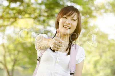 Young Asian college girl student thumb up