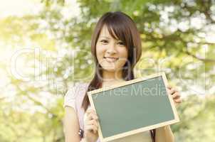 Young Asian college girl student with blank chalkboard