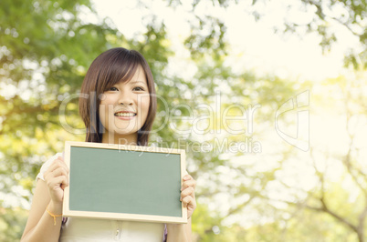 Young Asian college girl student holding blank chalkboard