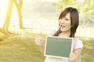 Asian female college student with blank chalkboard