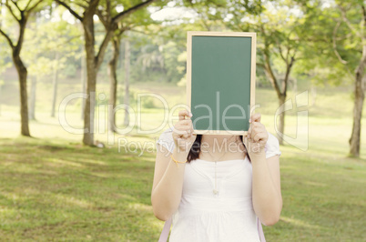 Asian female college student holding blank chalkboard