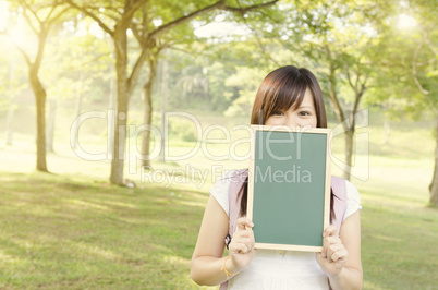 Asian female college student showing blank chalkboard