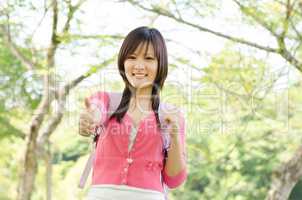 Young Asian college girl student showing thumb up