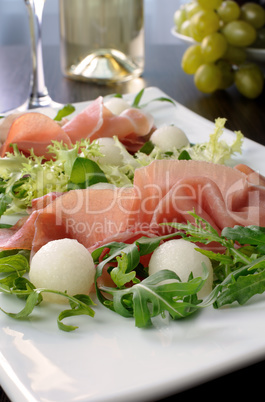 Arugula salad with ham and melon