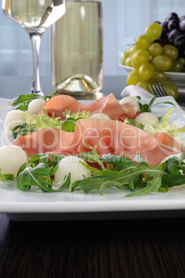 Arugula salad with ham and melon