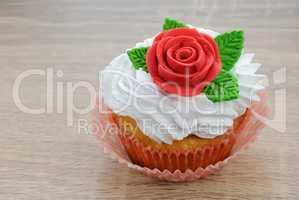 Muffin with cream decorated with sugar rose