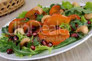 Salad greens with persimmon, pomegranate and cashews