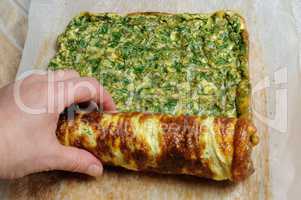 Fastening omelette with herbs in roll