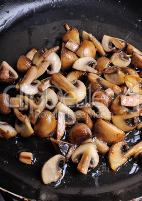 Fried sliced mushrooms in butter in a frying pan