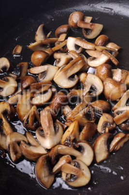 Fried sliced mushrooms in butter in a frying pan