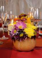 Autumn flowers in a vase on the table with pumpkin