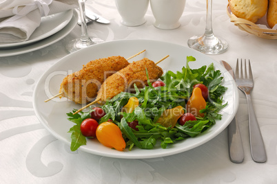 Chicken schnitzel garnish of arugula and tomatoes