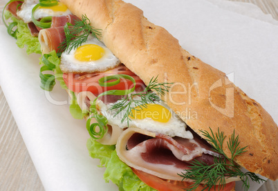 Big sandwich with ham, tomato and quail egg