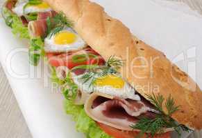 Big sandwich with ham, tomato and quail egg