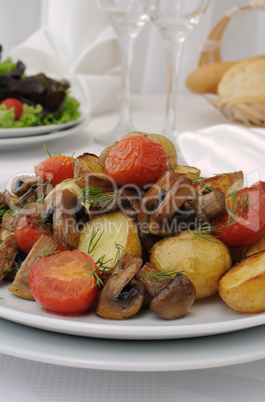 Fried potatoes with mushrooms and tomato