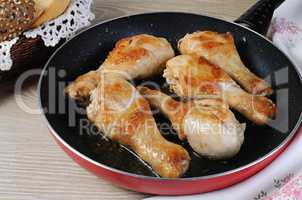 Ruddy fried chicken drumsticks in a pan