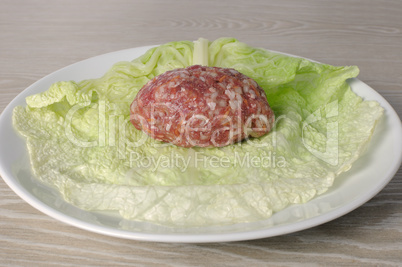 raw ground beef on a sheet of savoy cabbage