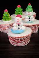 Sugar snowmen figurines on glazed muffins
