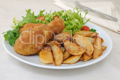 Chicken drumsticks with breadcrumbs with potatoes and salad