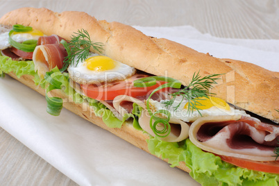 Big sandwich with ham, tomato and quail egg