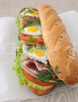 Big sandwich with ham, tomato and quail egg