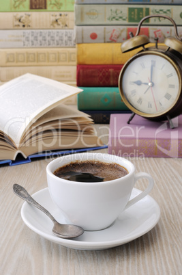 A cup of coffee on a table among books