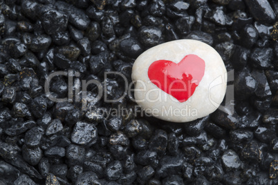 Red heart on white stone