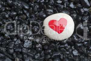 Red heart on white stone